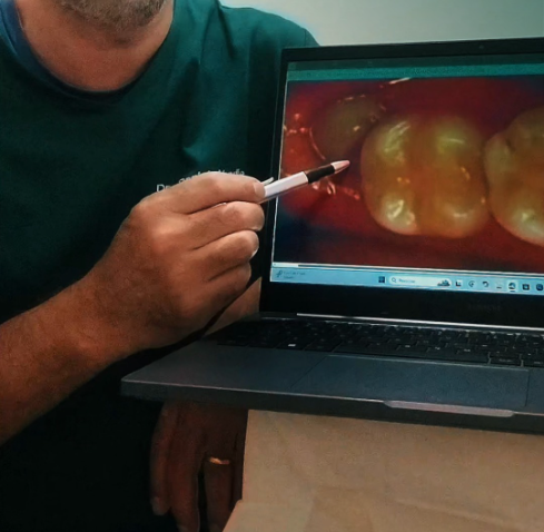 Dentista explicando imagem intraoral no notebook