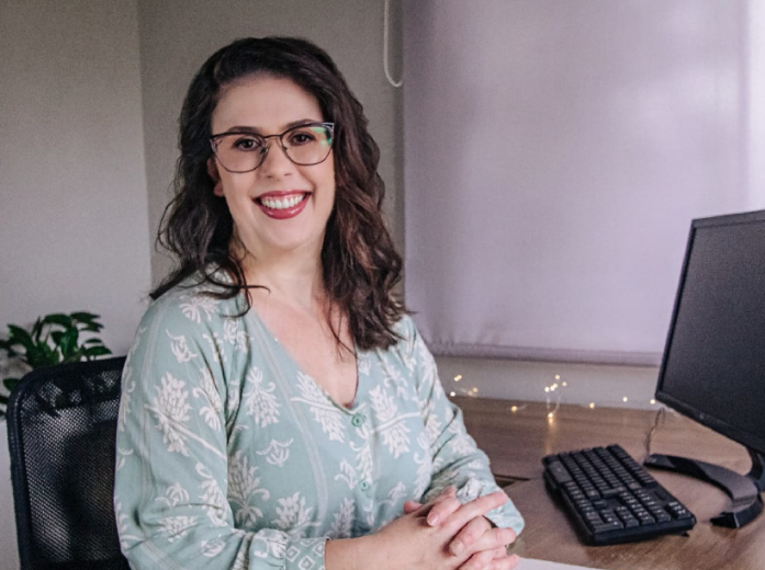Profissional sorrindo à mesa do consultório